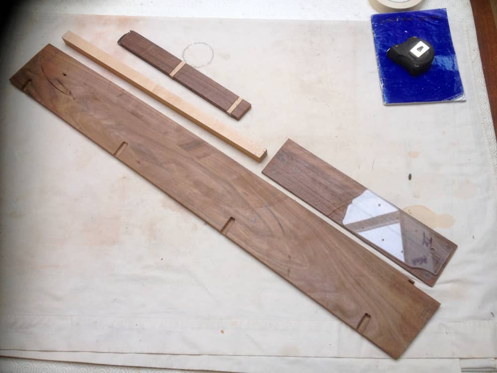 Rosewood for the bridge, headstock veneer & fingerboard. Maple for the trussed fillet.