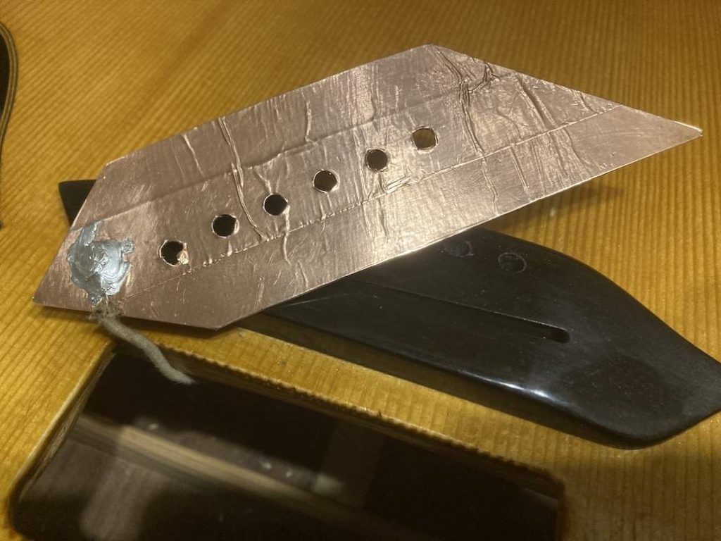Metal plate to ground the strings